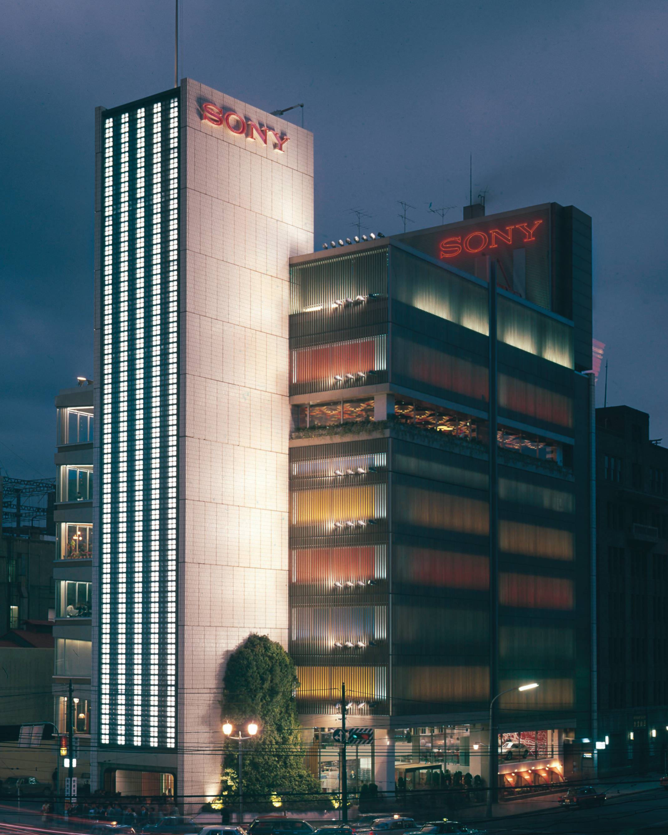 ソニービル外観。夜の数寄屋橋交差点越しのソニービル全景。交差点に面する手前のソニースクエア(屋外イベントスペース)には高さ3階分ほどの馬酔木の生木が植えられている。