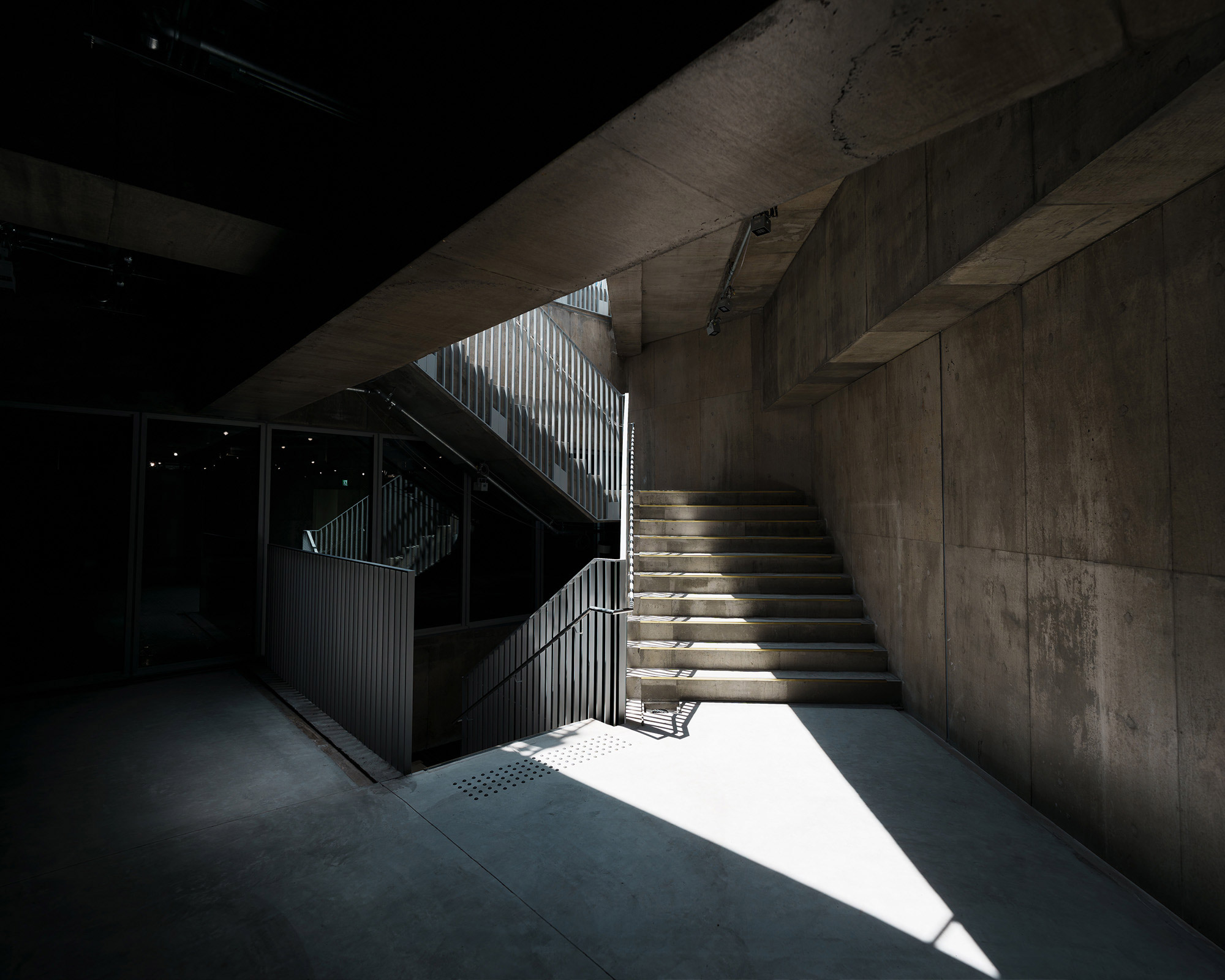 内観。階段踊り場に上から日差しが差し込んでいる。