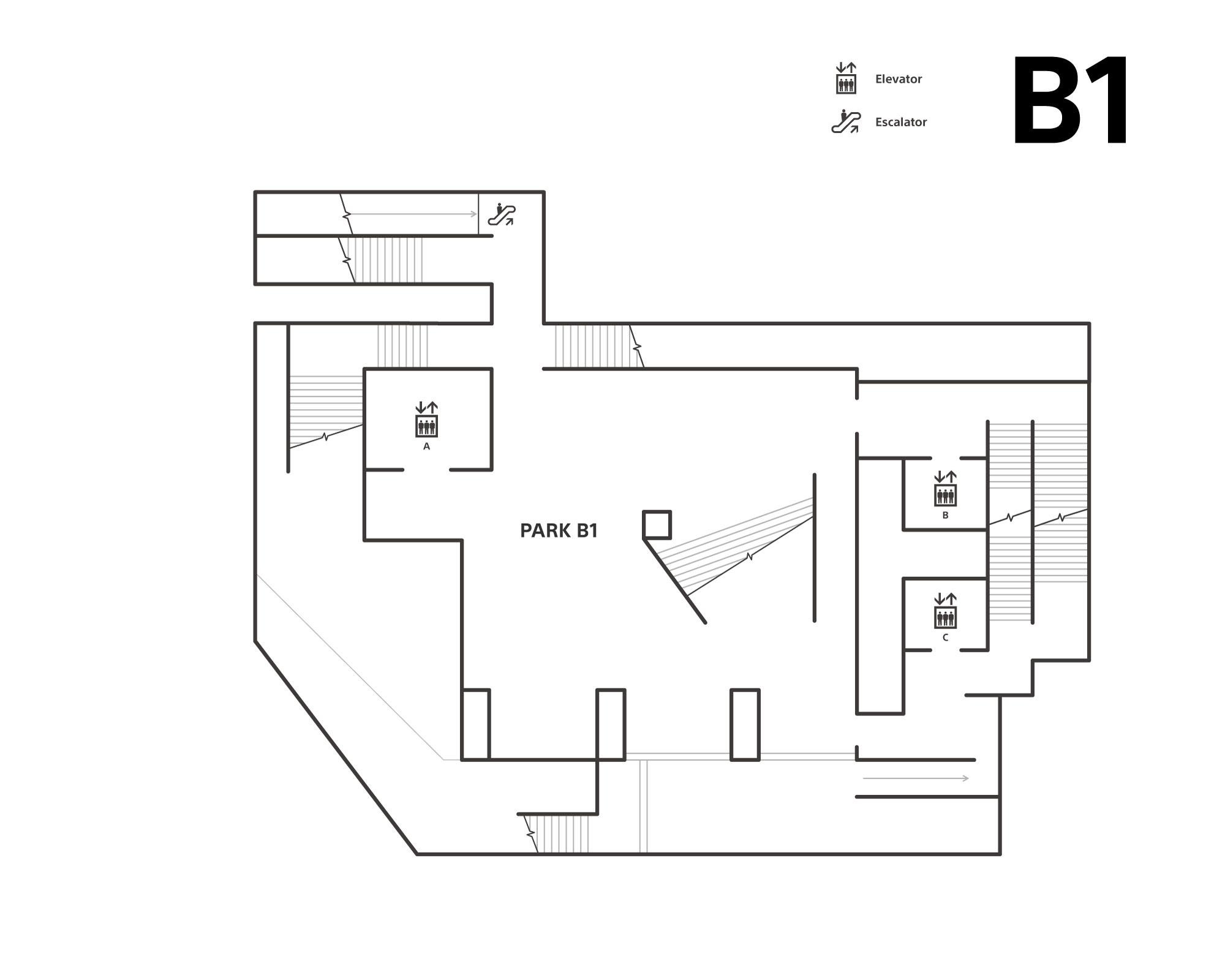 The first basement floor has an atrium in the middle of the floor. There are elevators (A, B, C) and stairs. There is an upward escalator that connects from the subway concourse.