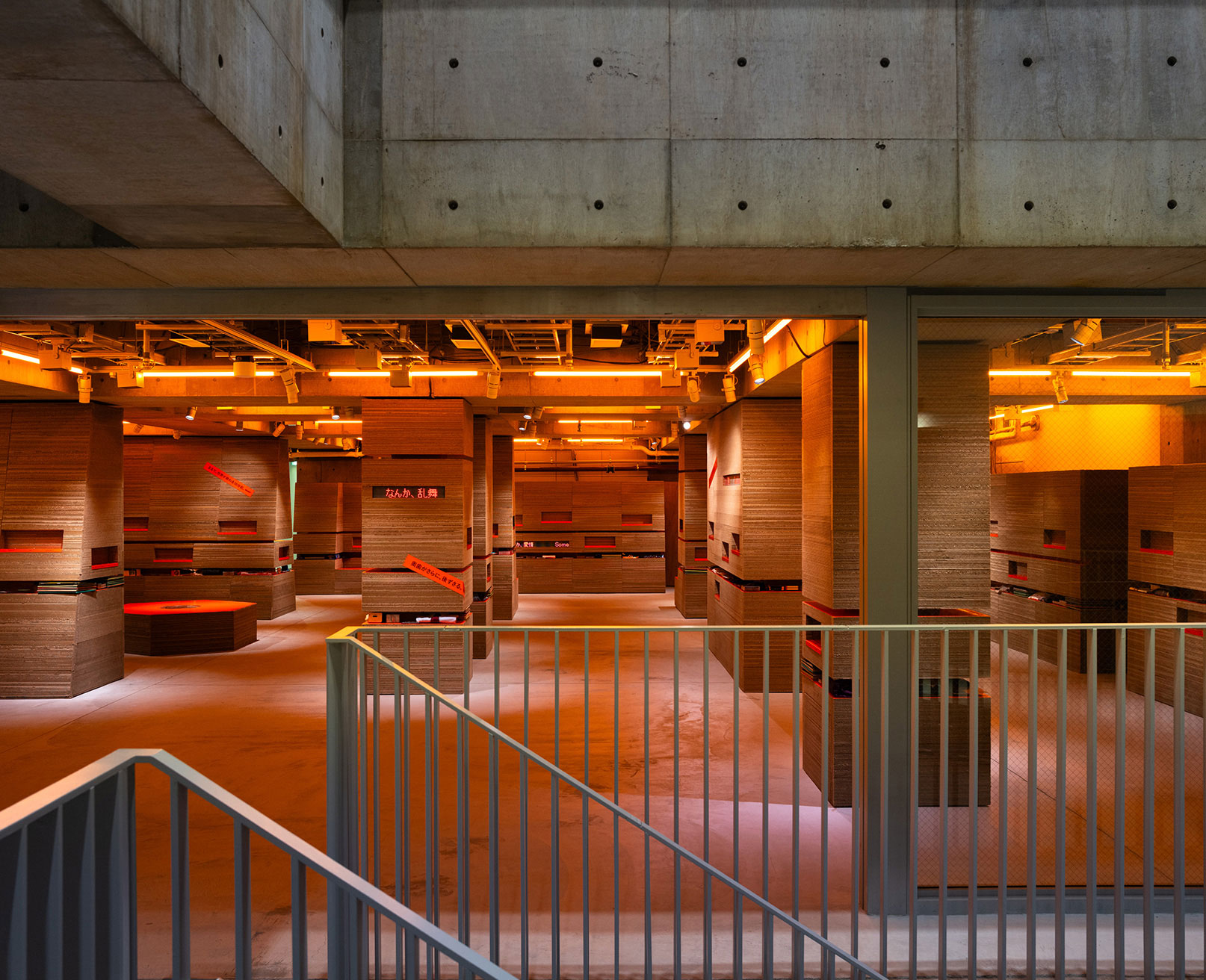 展示風景。地層のような壁面が並び、オレンジの照明で温かみのある雰囲気。