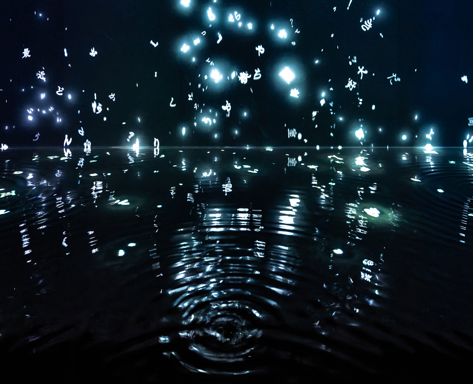 展示風景。暗闇の中、水面に反射する光の文字が広がる幻想的な様子。