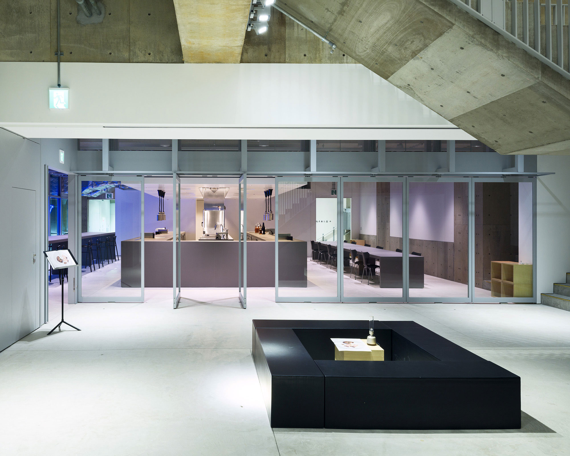 レストランの外観写真。手前にベンチ、回転扉の奥に厨房と客席が見える。