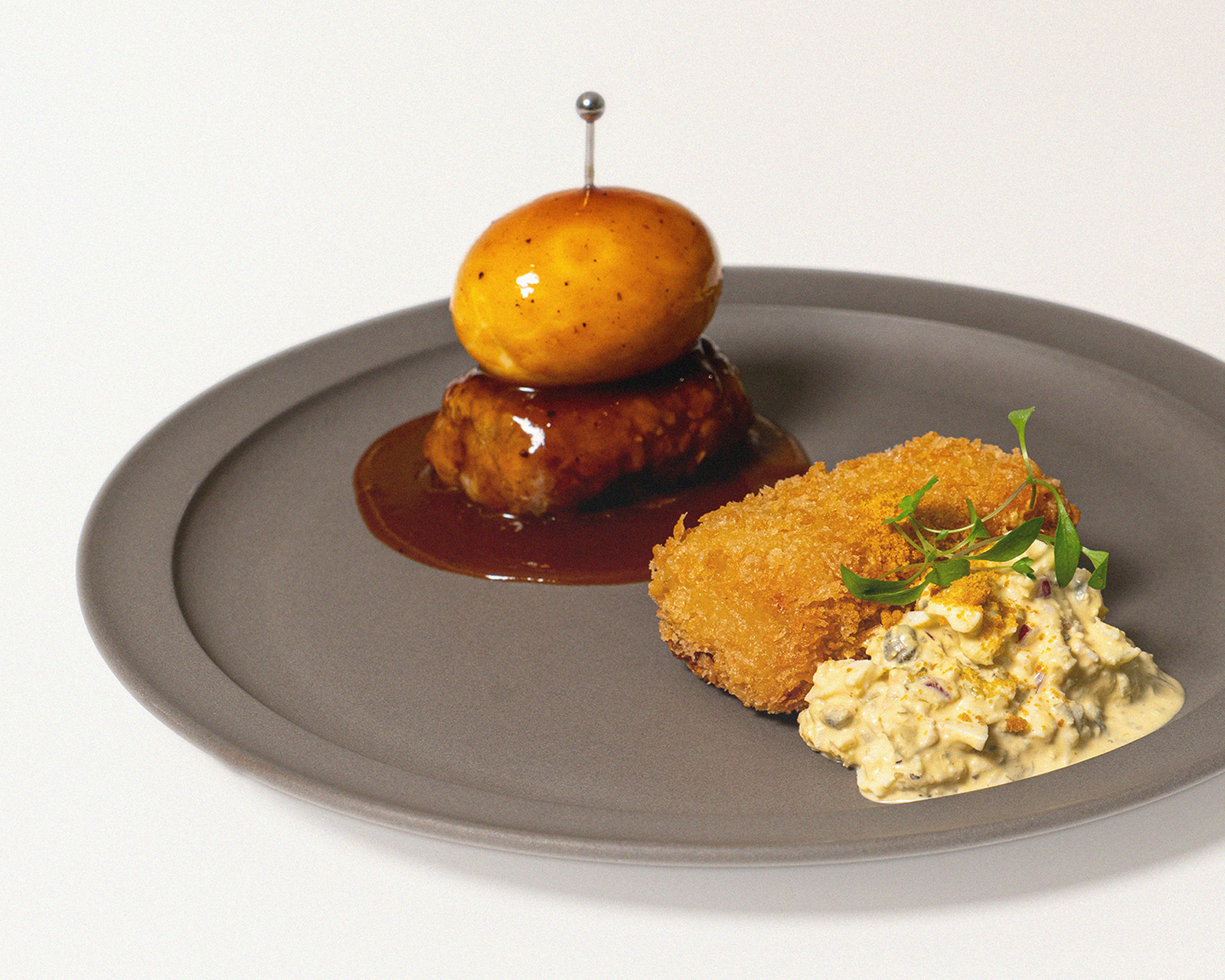 ゆで卵をのせたハンバーグとカニクリームコロッケを盛り付けた洋食プレート
