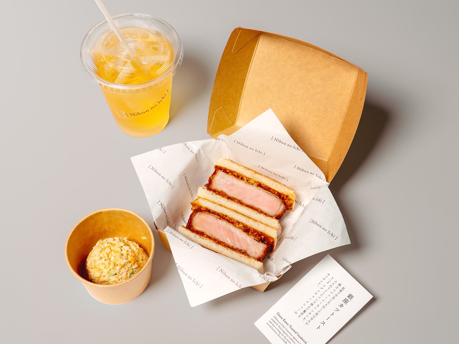 テイクアウトができる商品の一部。銀座カツトーストとリンゴジュースと自家製コールスローサラダの写真。