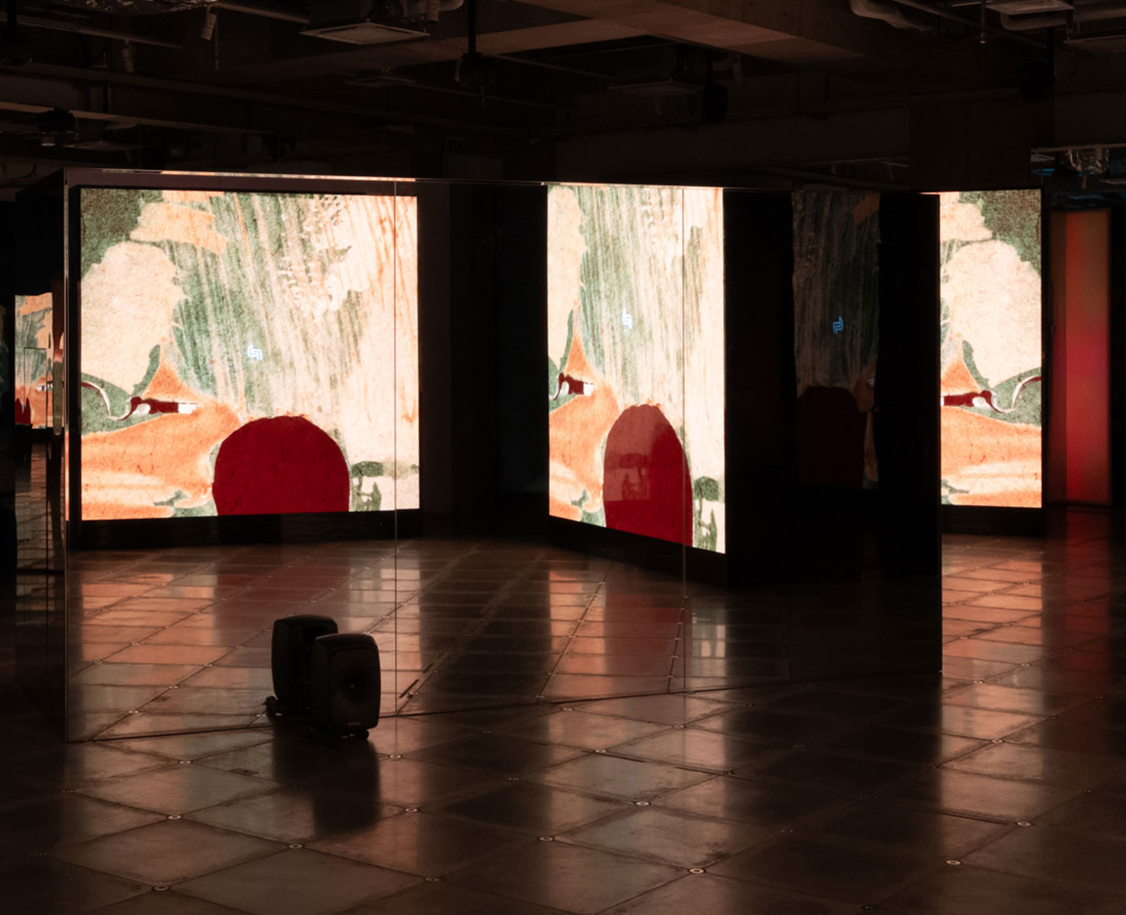 展示風景。薄暗い空間に、アニメーションが映し出されたスクリーンが複数設置されている。