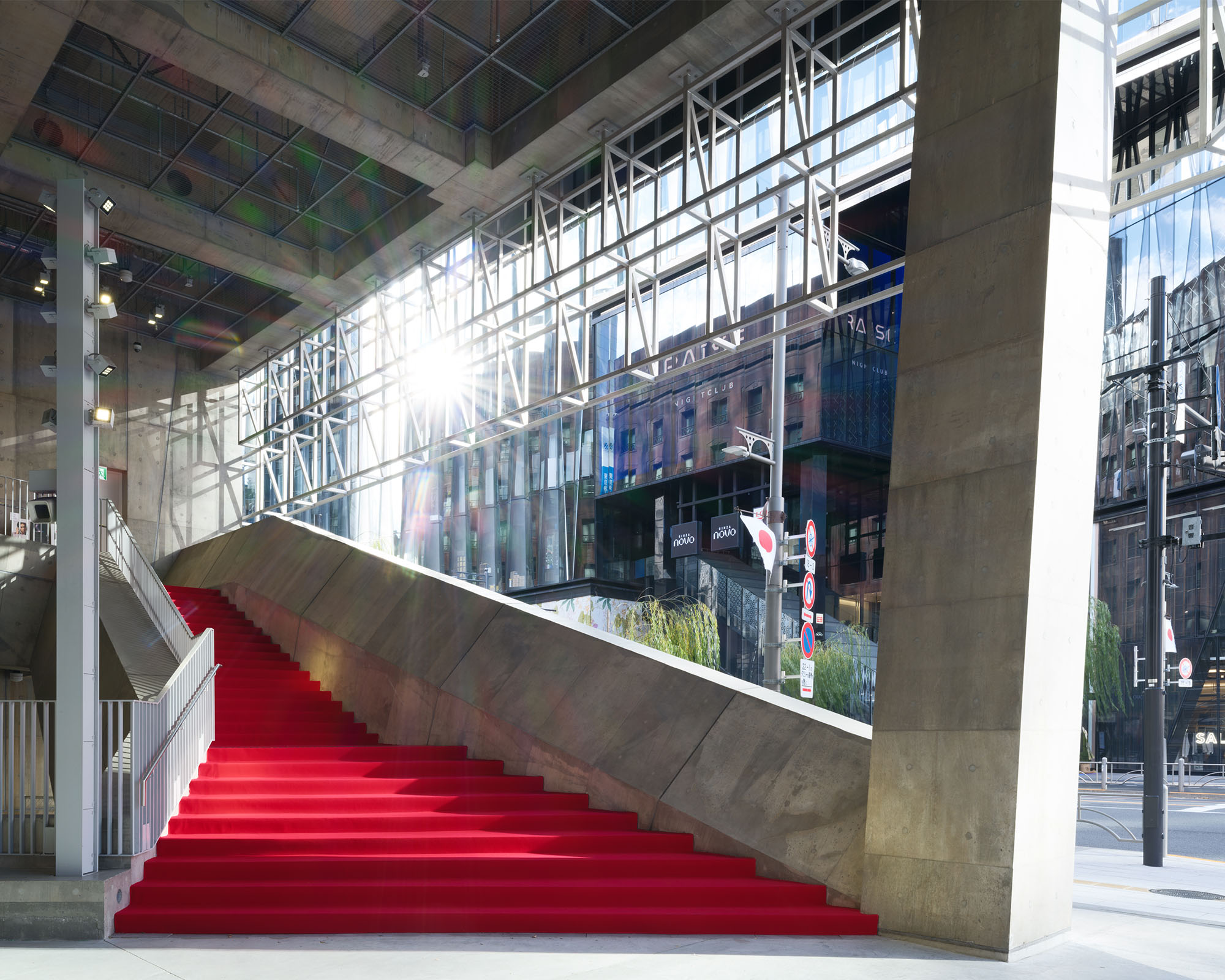 Ginza Sony Park館内の階段に敷かれたレッドカーペット。コンクリートの構造の中に鮮やかな赤が際立ち、外からの自然光が階段空間に差し込んでいる。
