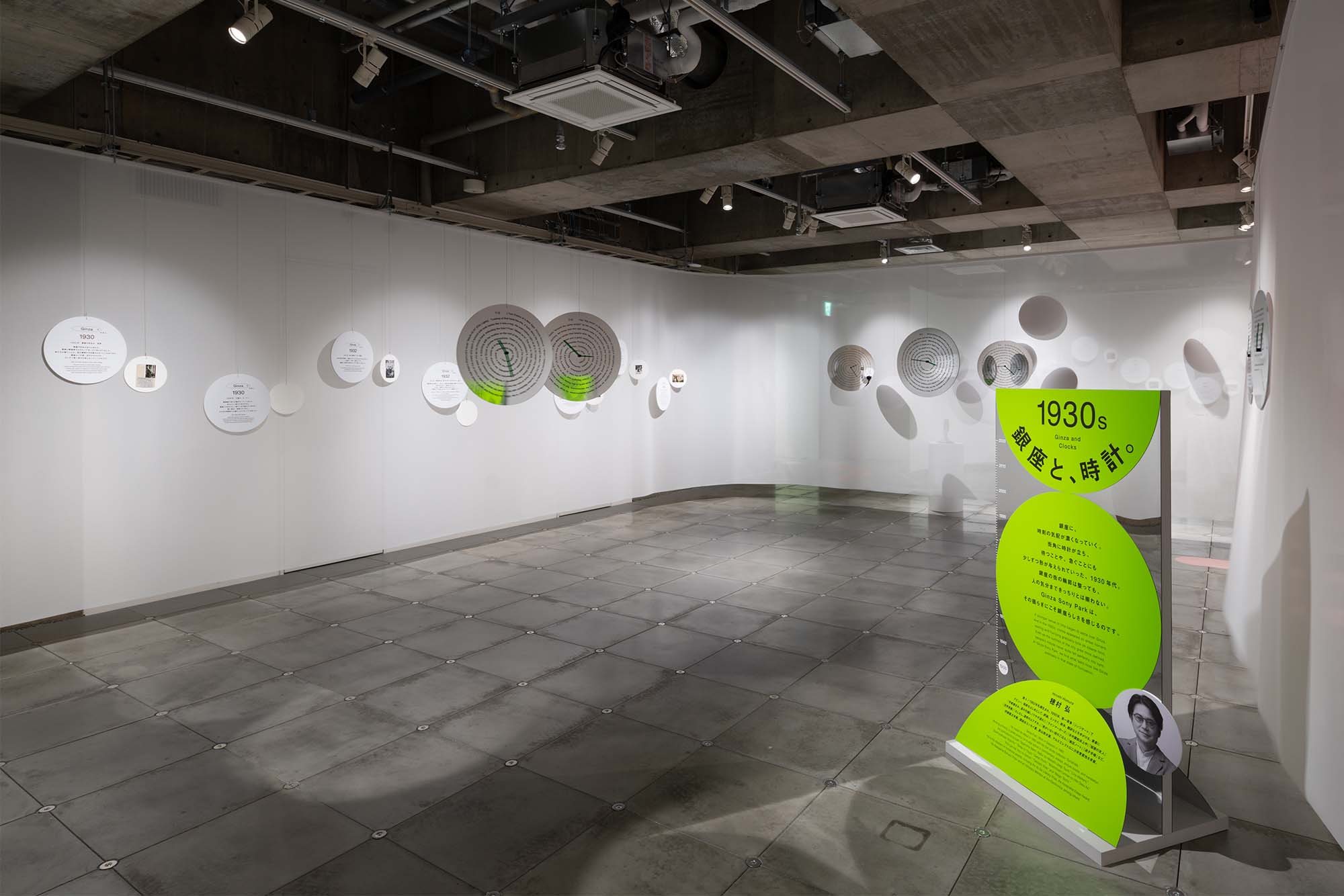 1930s section “Ginza and Clocks.” Circular graphic panels present essay texts about Ginza written by Hiroshi Homura.