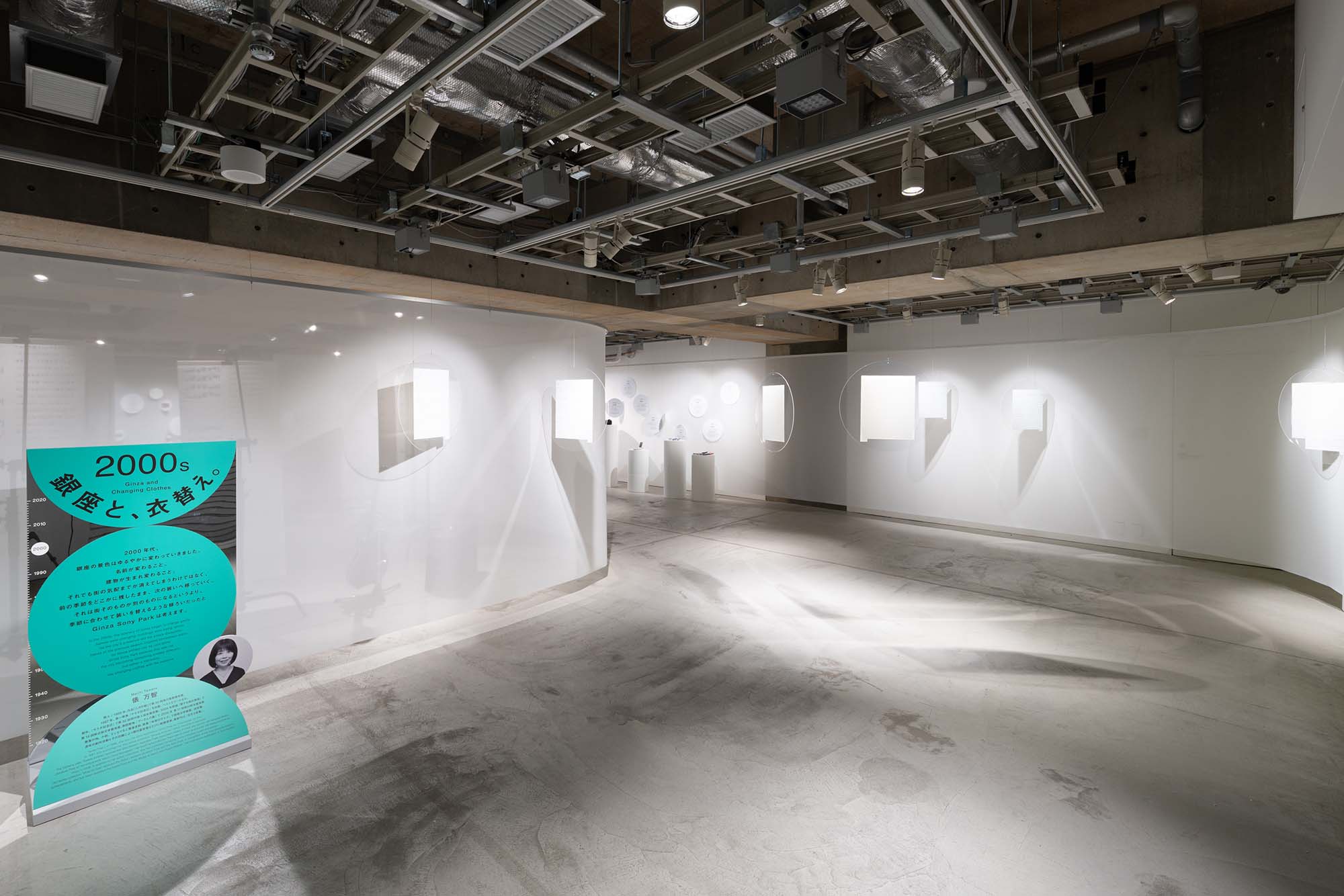2000s section “Ginza and Change” Panels on a white wall present essay texts about Ginza written by Machi Tawara.