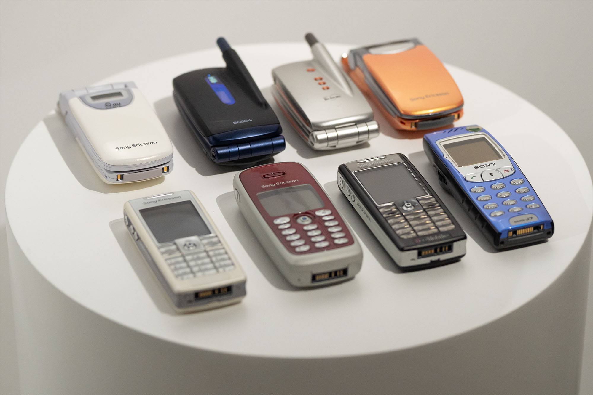Display of mobile phones from different periods, featuring products by Sony and Sony Ericsson.