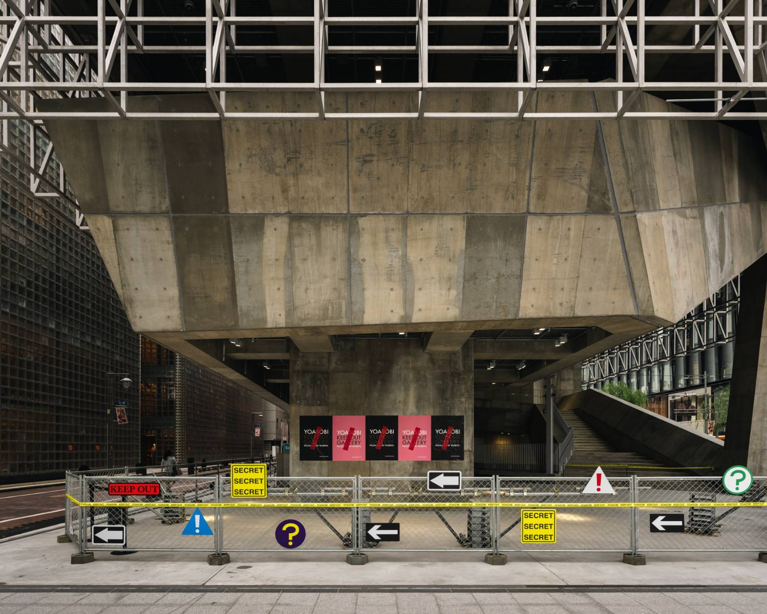 フェンスが設置され、フェンスと建物躯体にYOASOBI KEEP OUT GALLERYのサインやポスターが掲載されている。