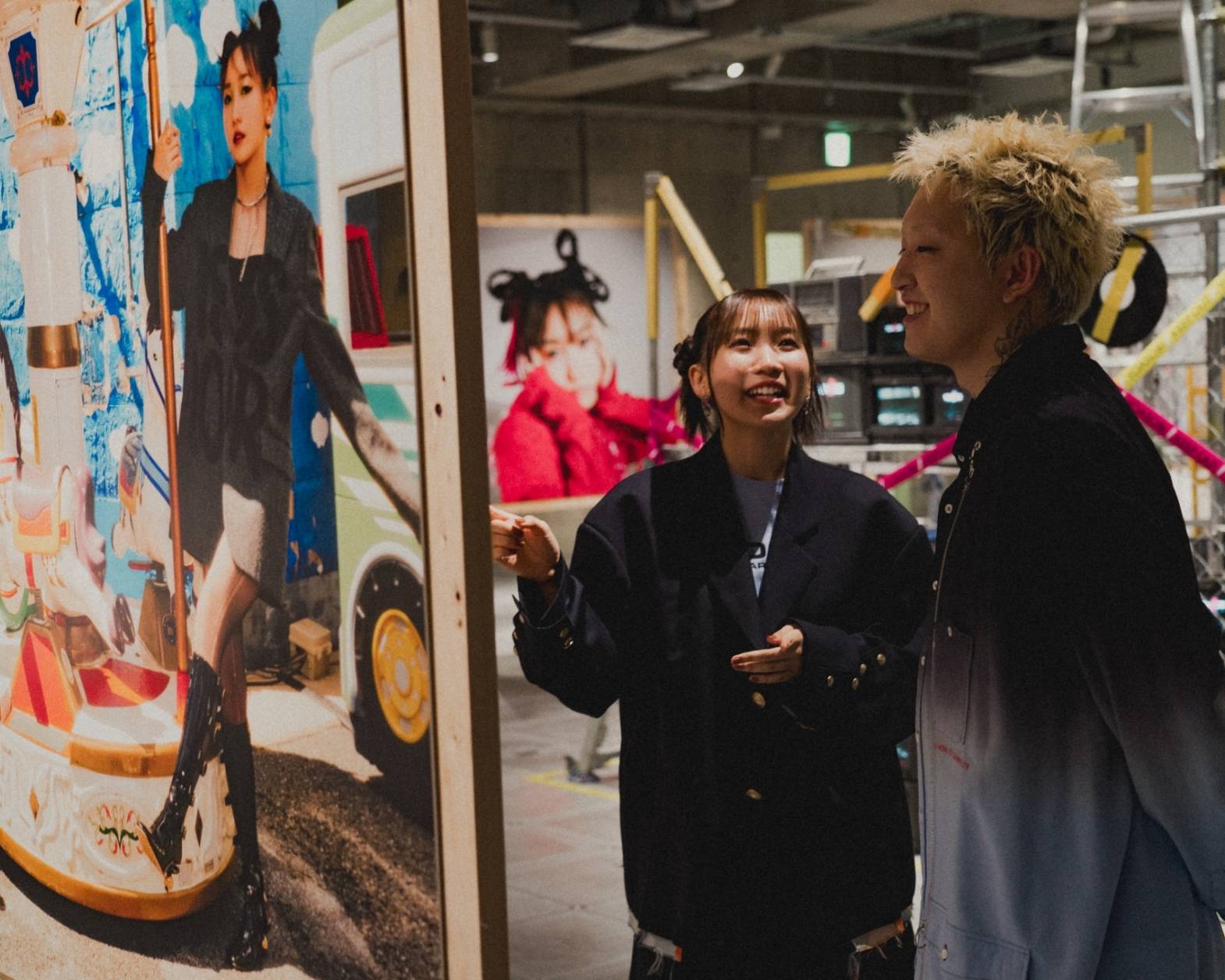 体験の様子。会場内の展示写真を見て楽しむYOASOBIの二人。