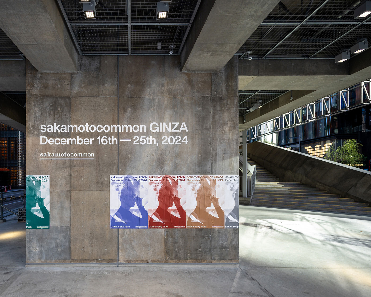 コンクリートの壁面には「sakamotocomon GINZA」のサインとポスターが貼られている。