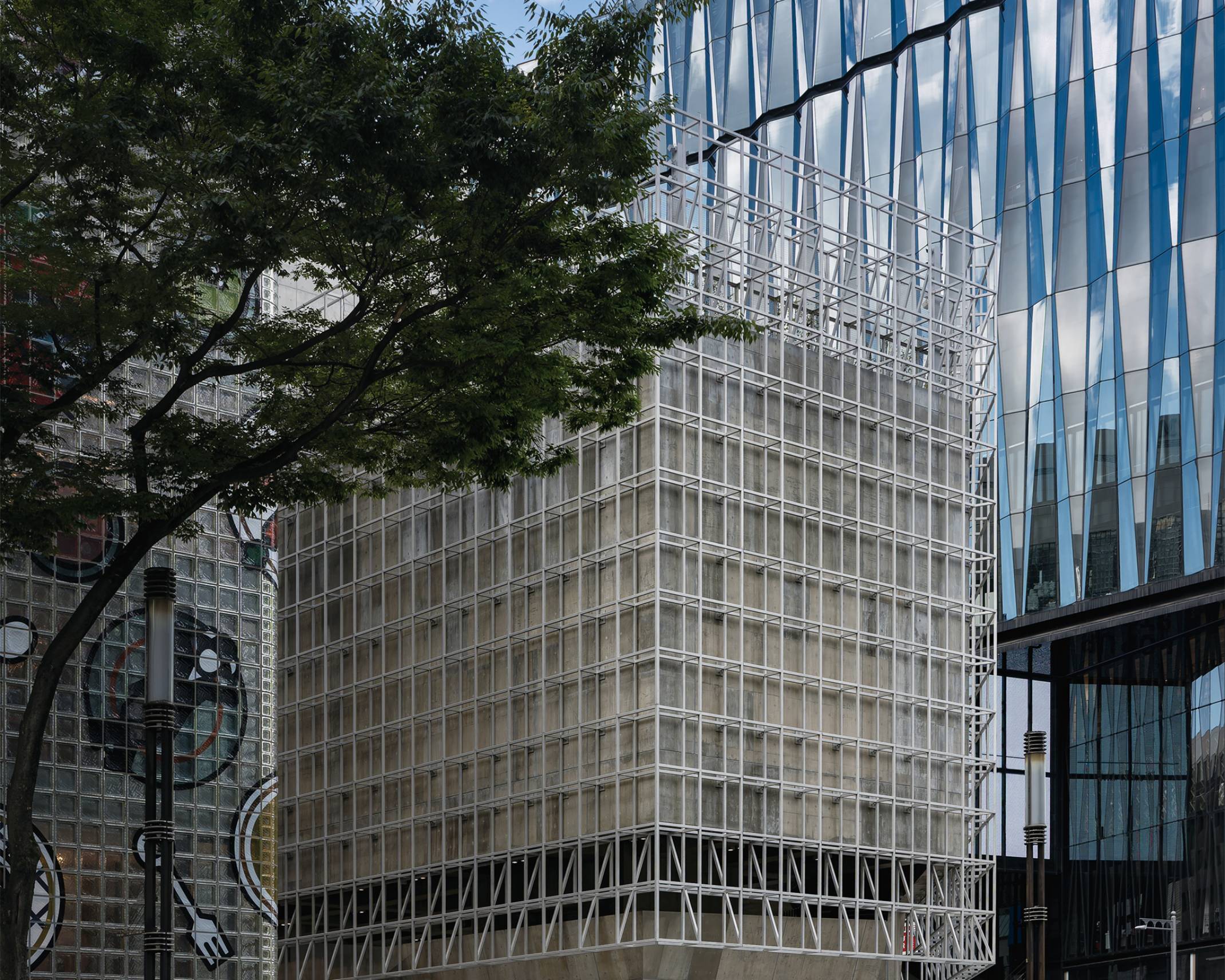 外観。グリッド状のファサードで覆われたGinza Sony Parkは、メゾンエルメスと東急プラザ銀座の間に低層で構えている。通りには街路樹がある。