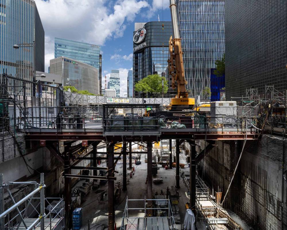 外観。日動火災ビル側から見た地下躯体工事。地下深くから伸びる構台の上にクレーン重機が載っている。