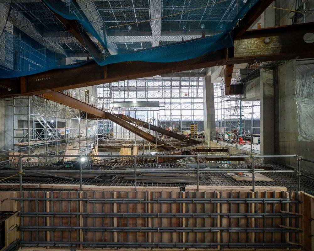 内観。ソニー通り側から見た工事中の吹き抜け空間にコンクリート型枠と階段の鉄骨が組まれている。