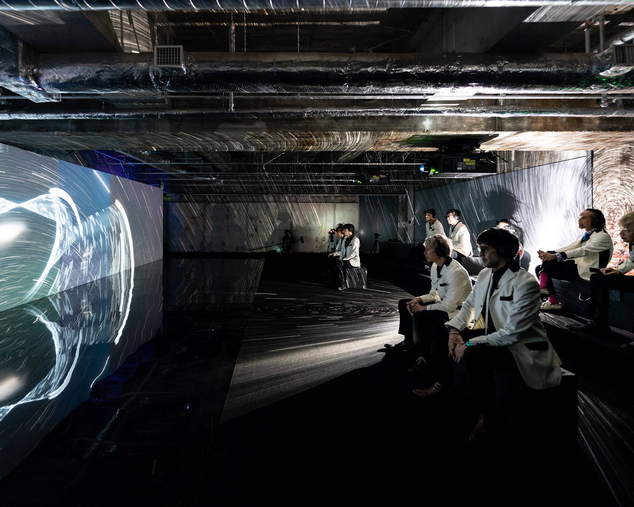 体験の様子。壁面に大きく投影されているプラネタポエムを東京スカパラダイスオーケストラのメンバーが体験している。