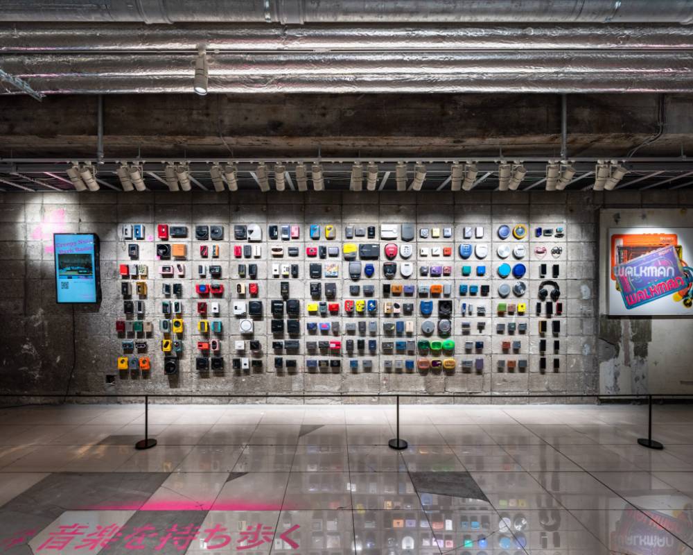 展示品。壁面に数多くの歴代のウォークマンの製品群がウォーホルの作品とともに展示されている。