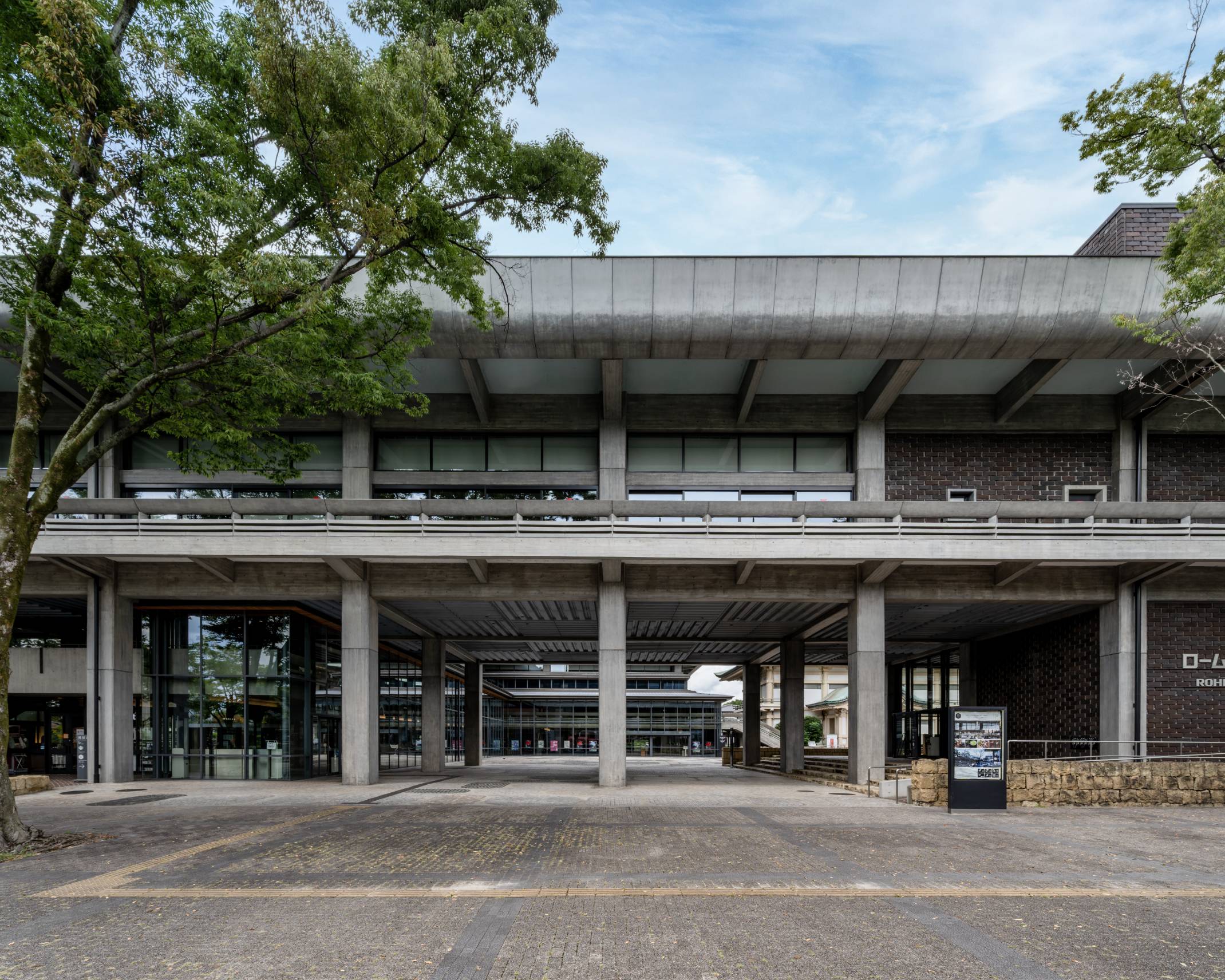 外観。横長な建物をくぐり抜けた先にはガラス張りのエントランスがある。