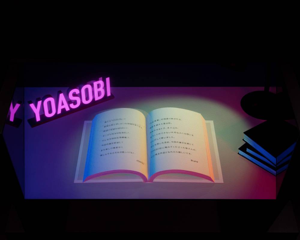 展示品。モニターに3DCGで表現された小説本とYOASOBIの電飾サインが投影されている。