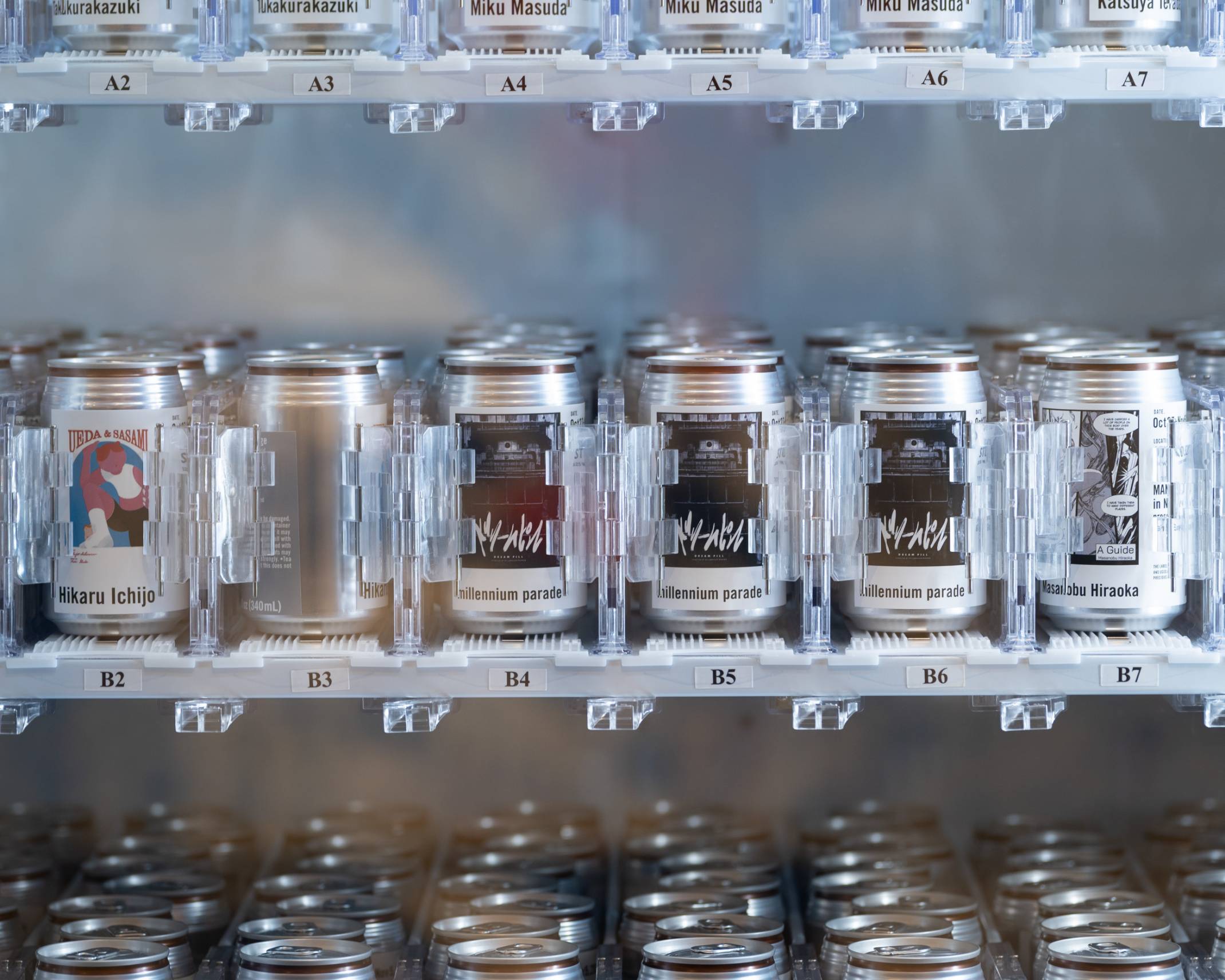 "マンガカン"の写真。それぞれのマンガの絵が印刷されたドリンク缶が自動販売機の中に並んでいる。