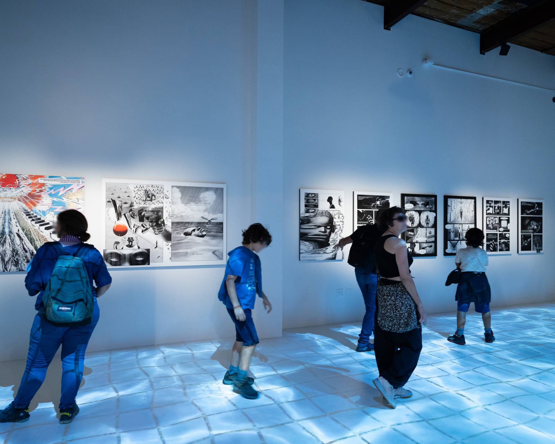 体験の様子。壁面に展示されているマンガや、床に映し出された水たまりの上を歩くインタラクションを楽しんでいる。