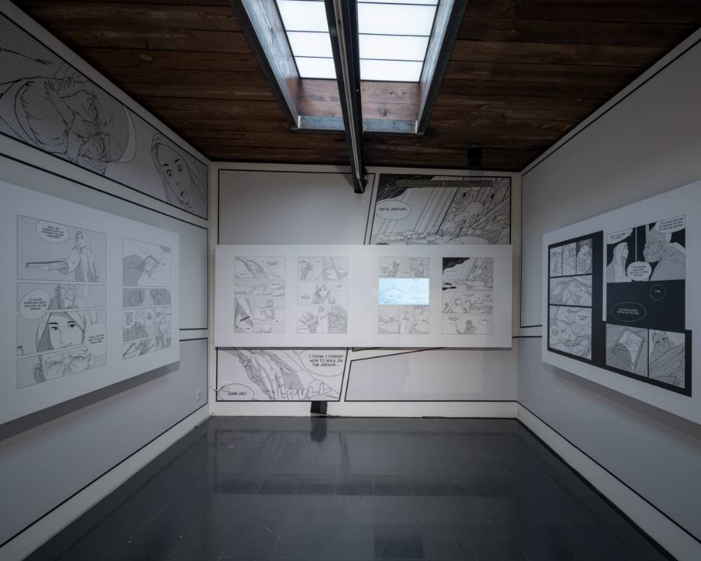 展示の様子。壁面にマンガが展示されている会場2階の天窓から光がやさしく射しこむ。