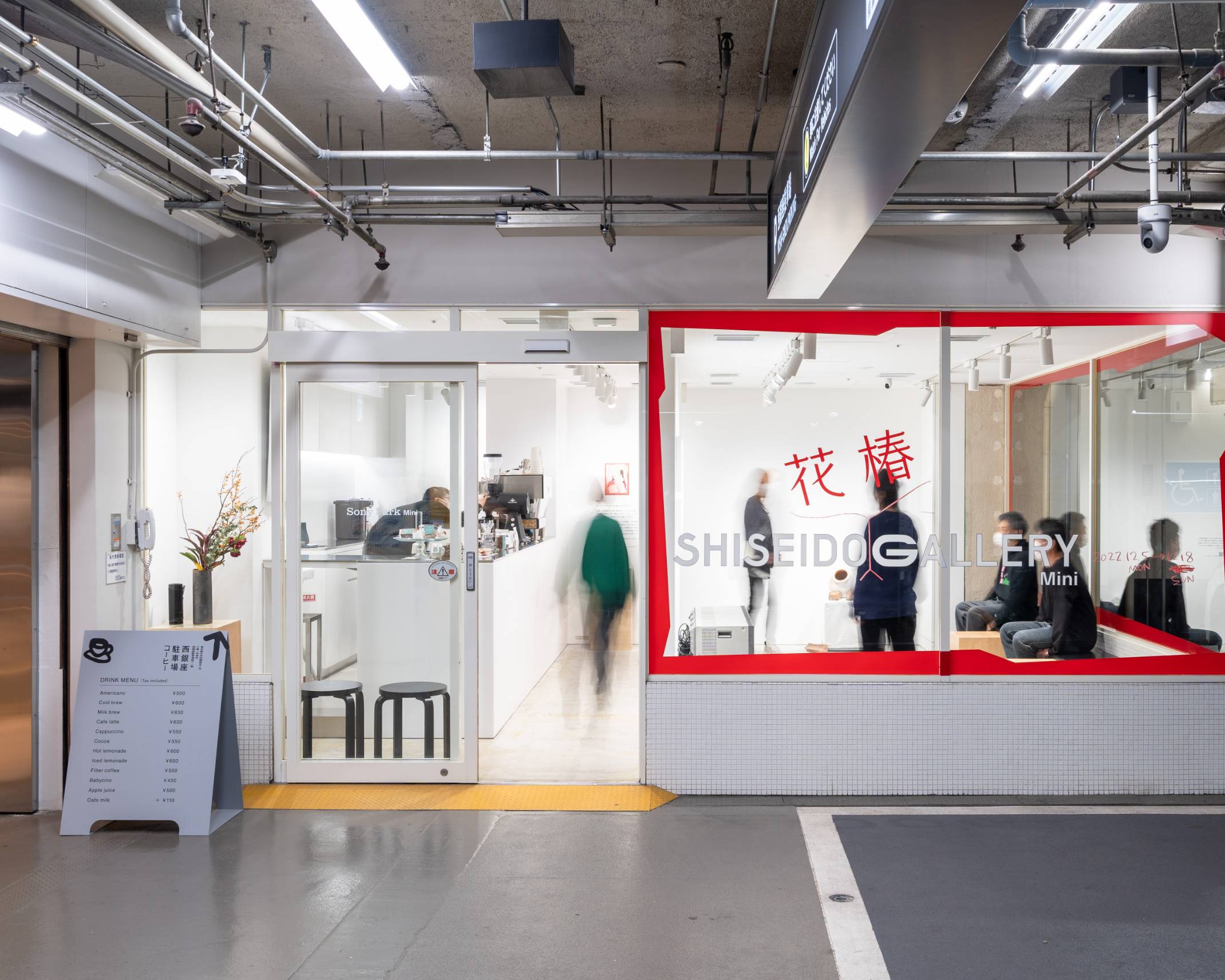 外観。ガラス面がメインビジュアルで飾られた展示スペースは来場者で賑わっている。