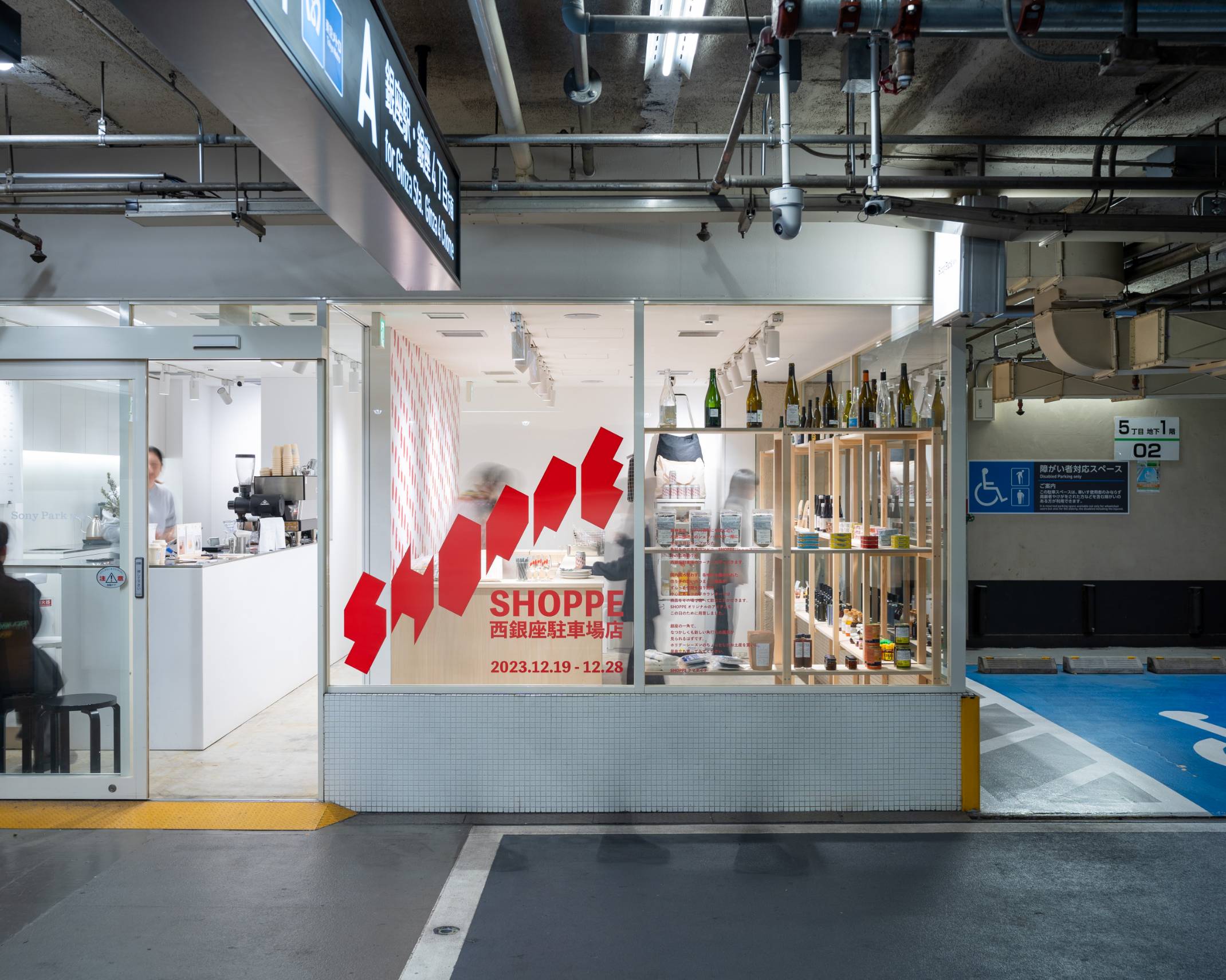 外観。木製の棚の上にさまざまな食料品や飲料などが並んだ角打ち風の展示スペースになっている。