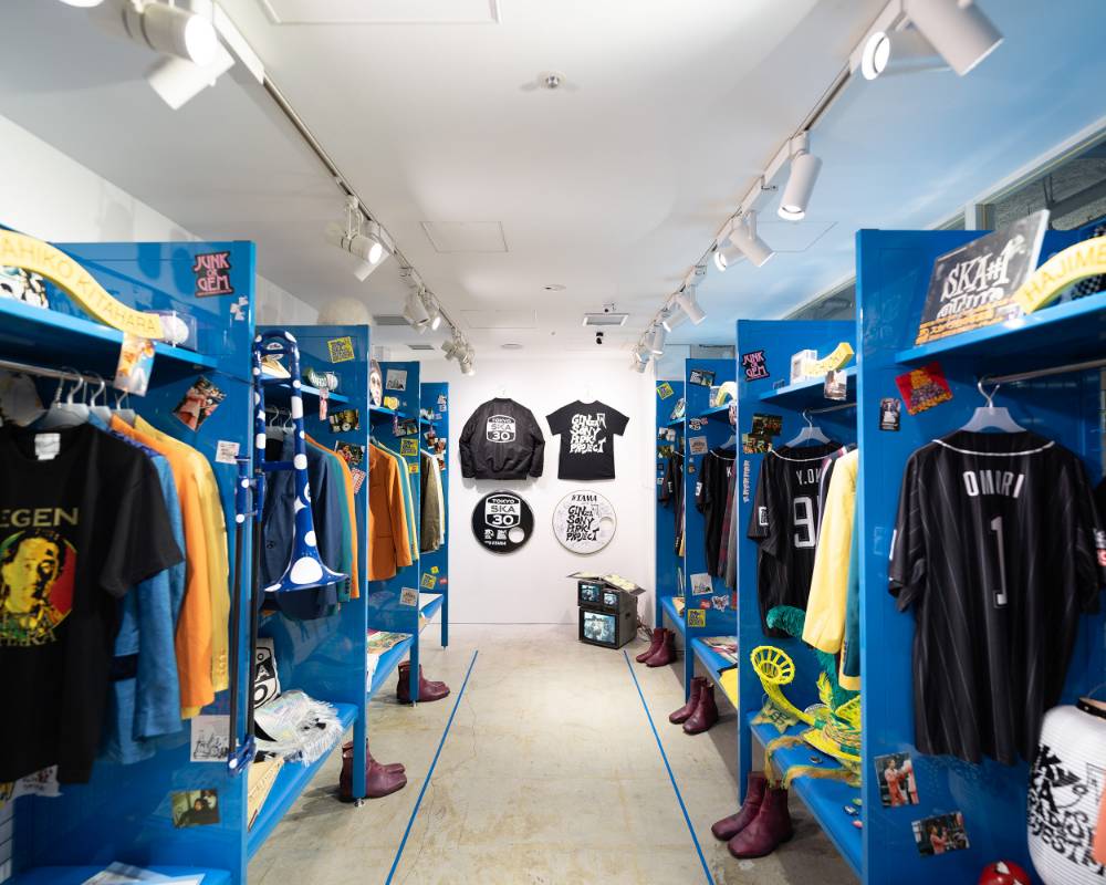 内観。ロッカールーム風のスペースに青い棚がありユニフォームやさまざまなアイテムが並んでいる。