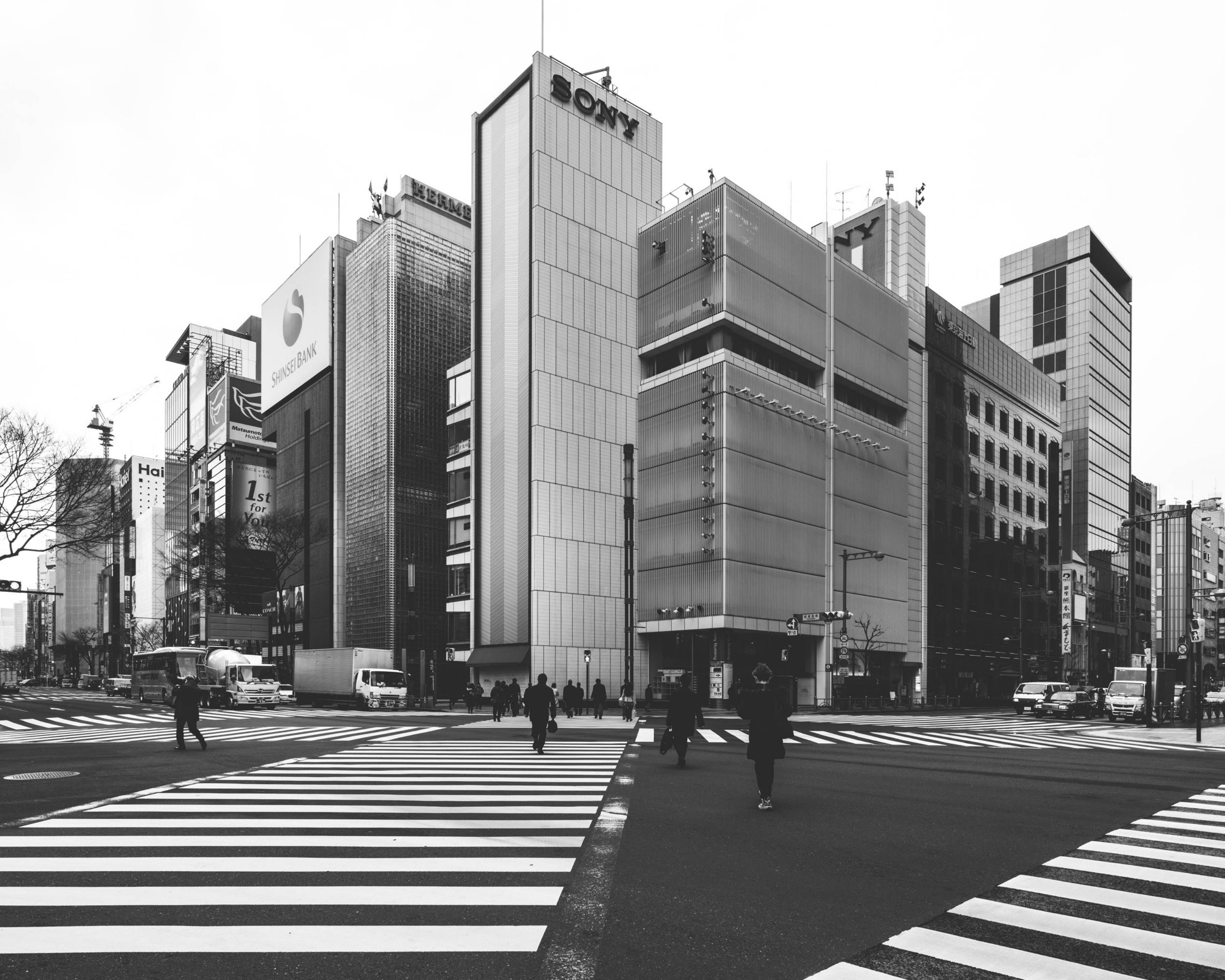 外観（モノトーン）。数寄屋橋交差点角に建つソニービル、交差する横断歩道を歩行者が渡っている。