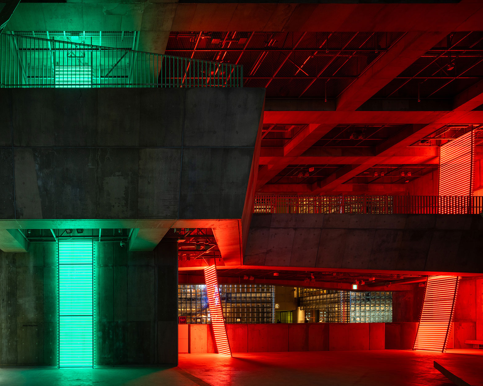 展示風景。コンクリート建築の空間で緑と赤のライトが光っている。