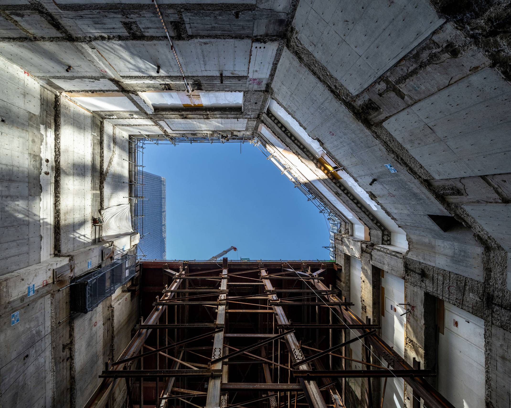 内観。地下外壁と工事用構台に囲まれた地下深くから仰ぎみた空。