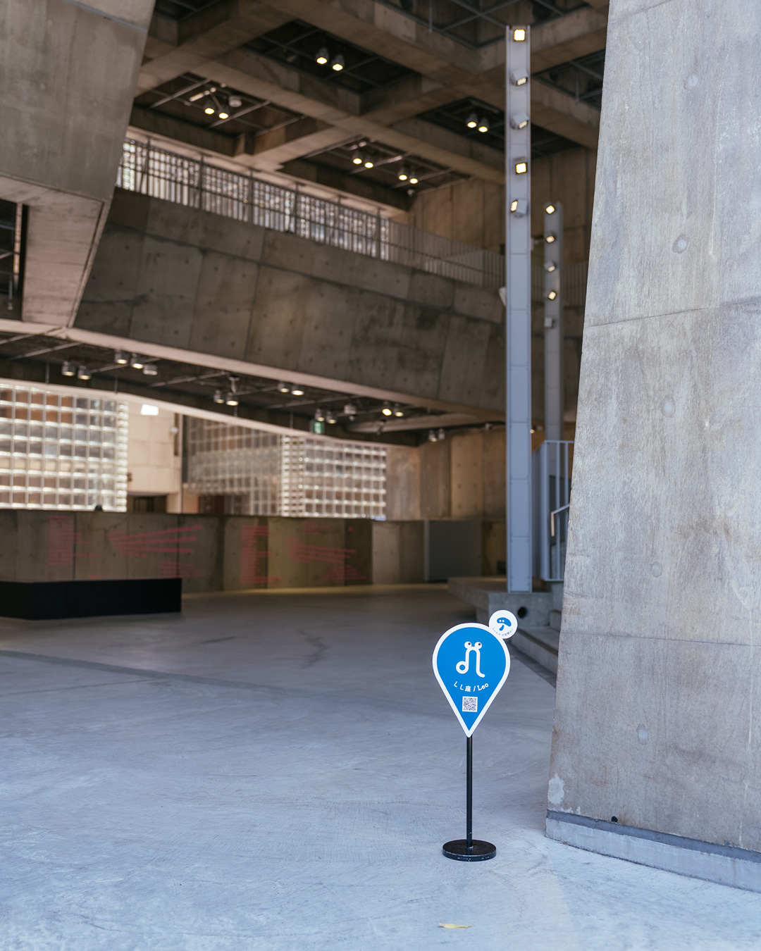 Ginza Sony Park内観。「しいたけ.の空間占い」のスポットサインが設置された、コンクリート柱が並ぶ広々とした空間