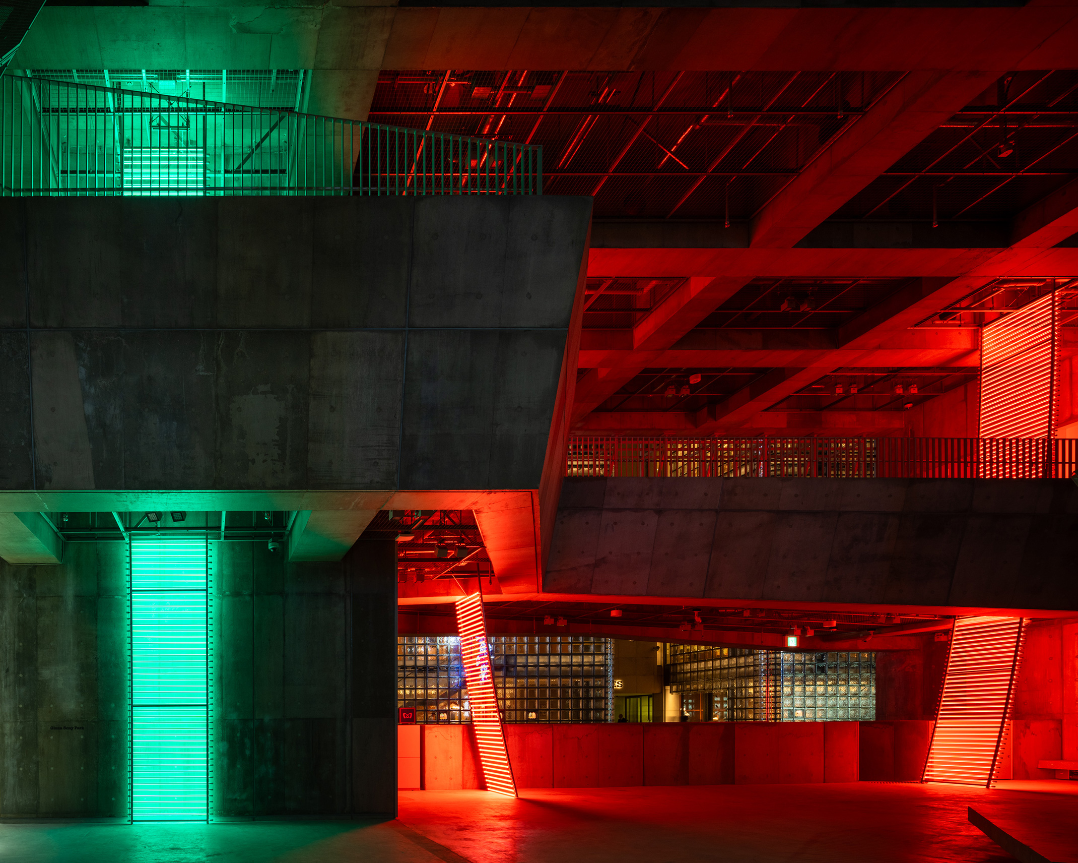 Ginza Sony Park内観。緑と赤のライトが印象的に照らす、コンクリート建築の吹き抜け空間。