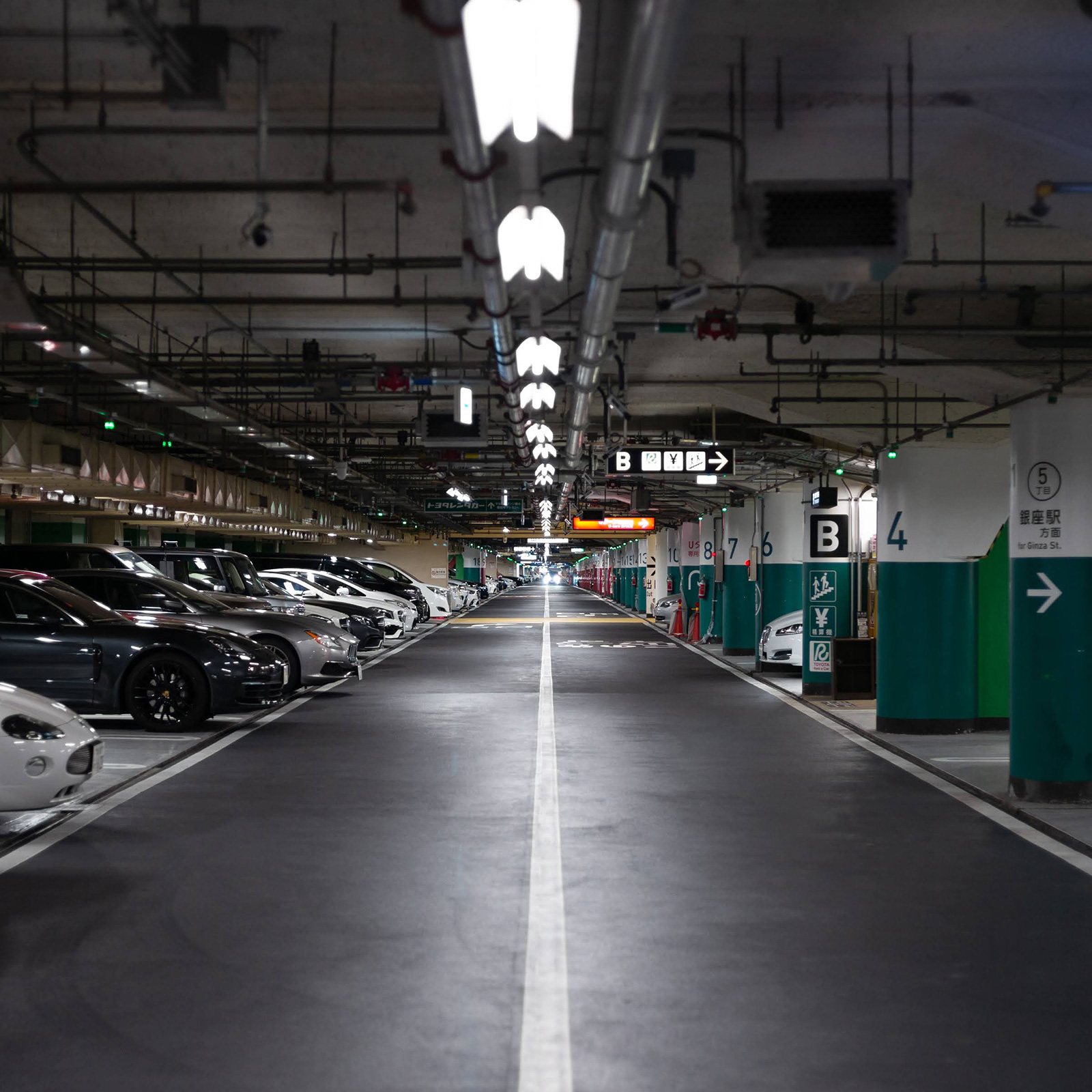 整然と車が並ぶ西銀座駐車場の内部。奥へ続く照明付きの車道。