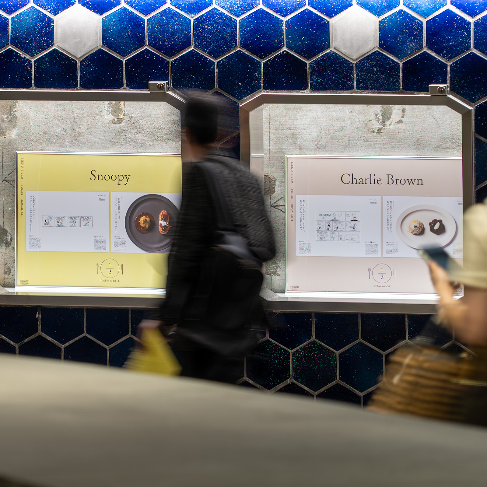 Ginza Sony Park 内観。青タイル壁のショーケースの中に、額装されたコラボメニューの写真がディスプレイされている。